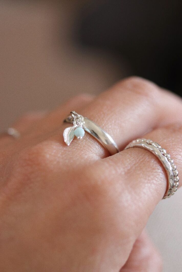 טבעת פס חלקה ודקה פתוחה מאחורה עם עלה קטן ואבן חן לרימר בצבע תכלת.jpg