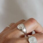 טבעת כסף חותם אליפסה עם פרח פלומריה מכסף טהור 925 עמידה במים.jpg