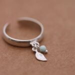 טבעת פס חלקה ודקה פתוחה מאחורה עם עלה קטן ואבן חן לרימר בצבע תכלת.jpg