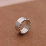 טס עבה מרוקעת מעוטרת בפרופיל כדוריות כסף קטנות